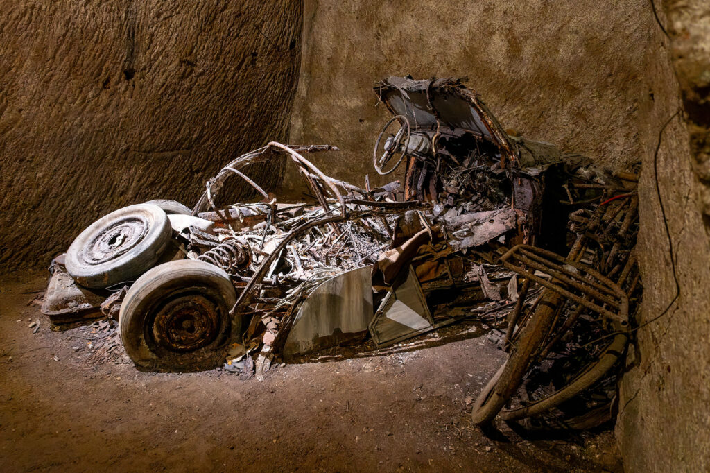 The skeletal remains of an old car that has almost completely rotted away