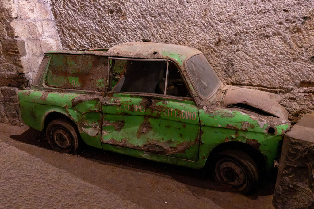 An abandoned green van with writing on the side